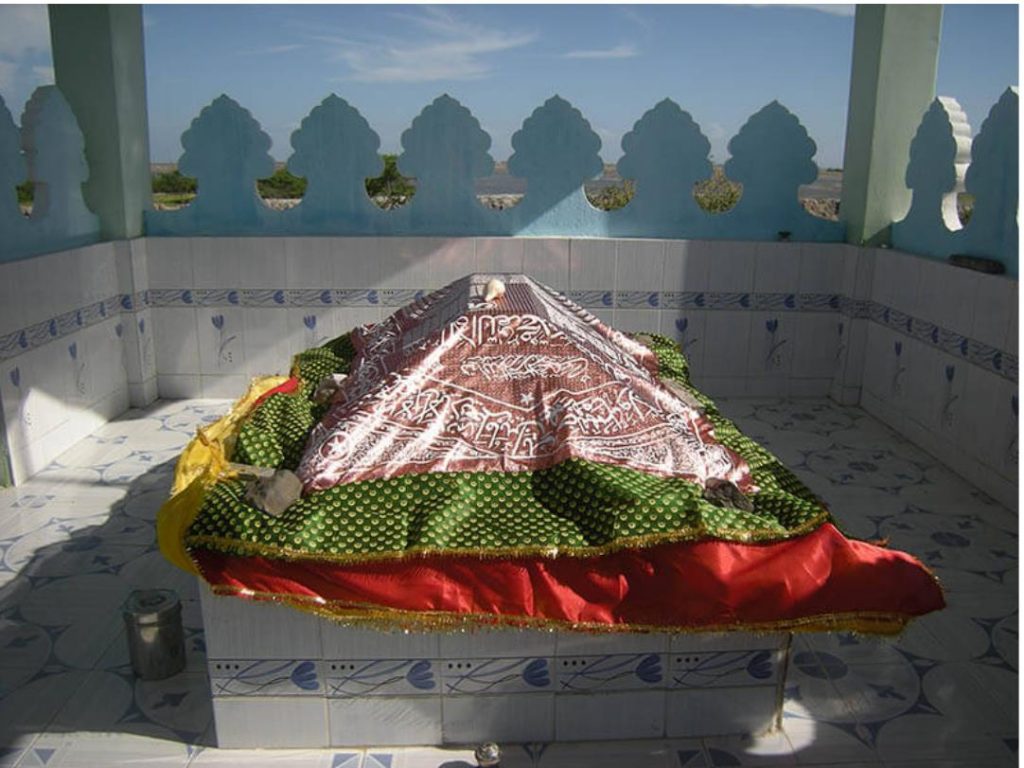 インド、グジャラート州 カッチ県の港町ムンドラー郊外にある聖者墓に掛けられたダルガー・チャーダル。中央の赤字の布にはモスクの形にアッラーの美名がプリントされている。2011年　鈴木英明撮影