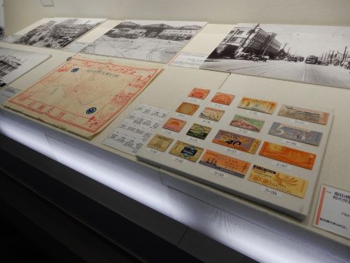 右手前は、昭和初期から昭和34年までの市電・都電乗車券。左奥は、市電の路線が描かれた三越呉服店の包装紙。