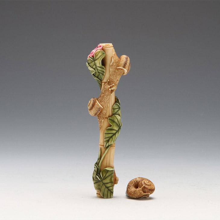 「巡り会い」福山 恒山 素材：象牙材 サイズ：8.5cm、〈緒締〉1.6cm 朝顔の竹垣で出会ったカタツムリを作品にしました。緒締までもが精緻に彫り込まれており、匠の技を感じられる作品です。