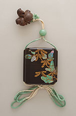 2) 印籠および印籠箪笥より 豆蒔絵螺鈿印籠 江戸時代　国立歴史民俗博物館蔵  緑味を帯びた螺鈿を引き立てるため、緒締や紐の色合いを合わせたもの。