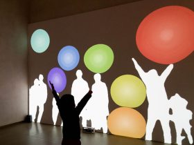 映し出された自分の影によって、はずむボールに触れたり弾いたりする体験ができます。 《Immersive Shadow: Bubbles》藤本直明　© naoaki FUJIMOTO