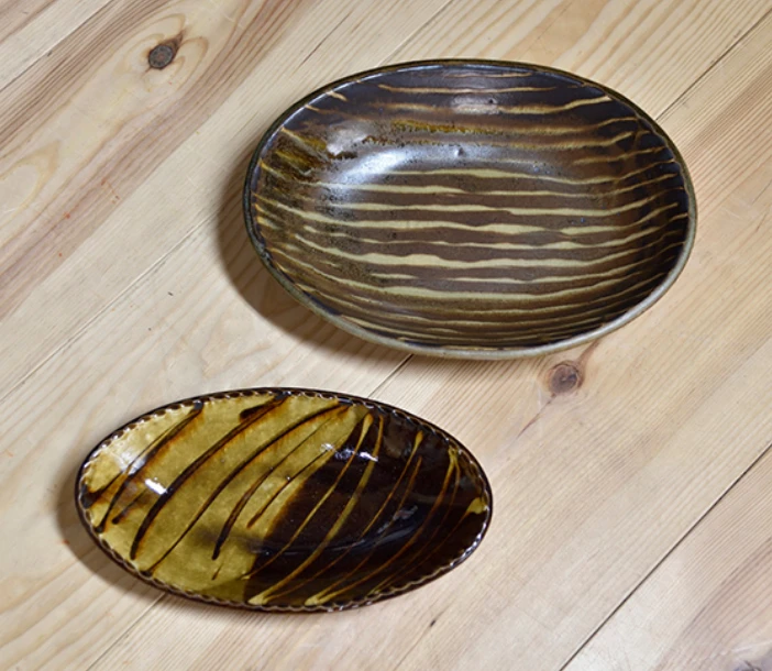 上から
「灰釉スリップウェア楕円皿」
（幅34×奥行25×高さ6.5cm）
「飴釉掛分スリップウェア長楕円皿」
（幅29.8×奥行17×高さ4.5cm）