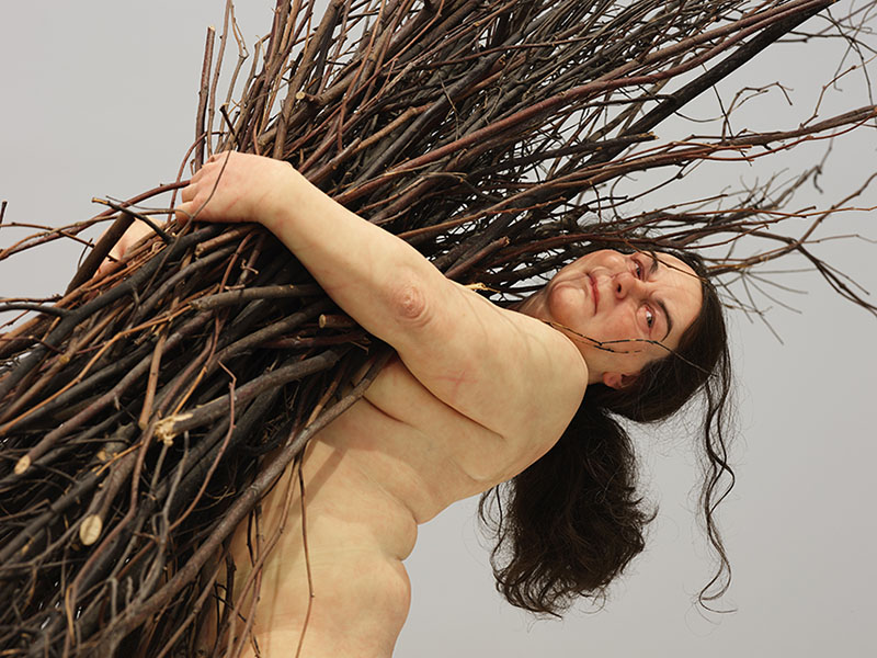 ロン・ミュエク《枝を持つ女》2009年　ミクストメディア　170×183×120cm
所蔵：カルティエ現代美術財団　展示風景：「ロン・ミュエク」韓国国立現代美術館ソウル館 2025年　撮影：ナム・キヨン　画像提供：カルティエ現代美術財団、韓国国立現代美術館