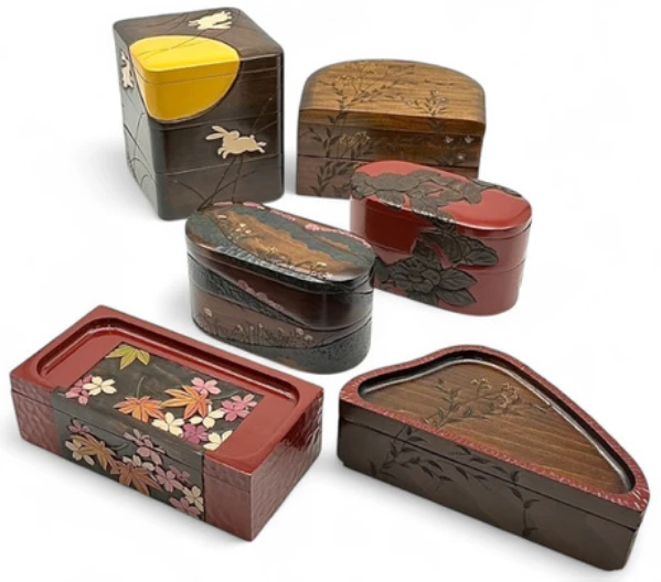 上段左より 「姫三段・月うさぎ」 （幅15×奥行15×高さ19cm） 「彩り弁当箱・野草」 （幅15.5×奥行20.5×高さ11.5cm） 「姫遊山箱・山景色」 （幅18×奥行9×高さ10cm） 「姫遊山箱・椿 赤」 （幅18×奥行9×高さ10.5cm） 「春秋弁当箱・桜 もみじ」 （幅21.5×奥行11×高さ7cm） 「摘草弁当箱・たで おみなえし」 （幅23×奥行12×高さ7cm）