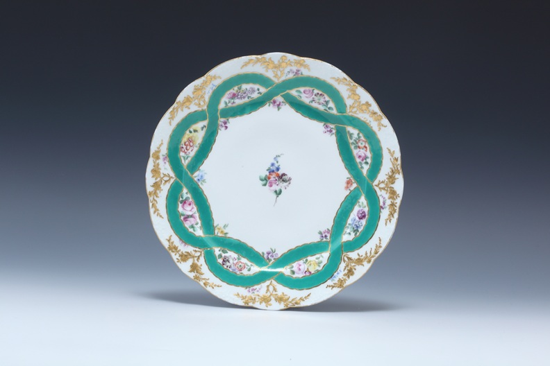 「金彩花絵緑のリボンと花のガーランドディナープレイト」ルイ15世よりオーストリアのマリア・テレジアに贈られたディナーサービスの中の1枚。1758年、直径25cm　